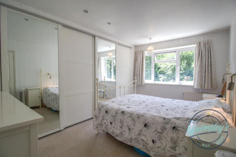 Main bedroom with fitted wardrobes and garden view