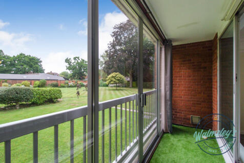 Enclosed balcony with sliding doors overlooking ga