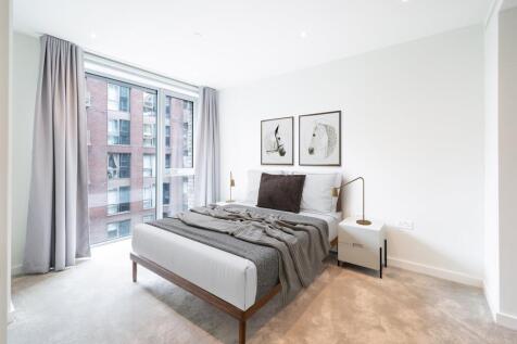 Experience relaxation in this sophisticated bedroom, featuring ample natural light and chic design.