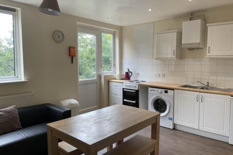 Bright fitted kitchen with white cabinetry, int...