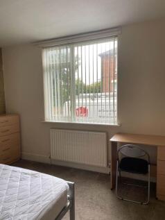 Bright, simply furnished bedroom with a large w...
