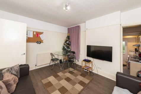 Bright communal lounge with wall-mounted TV, co...