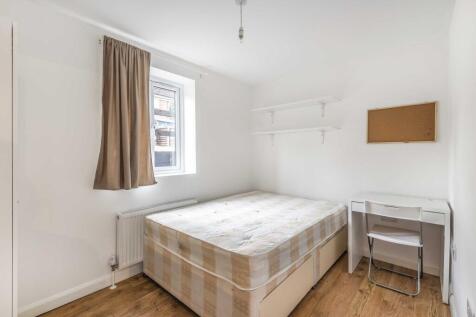 Bright, simply furnished bedroom with a double ...
