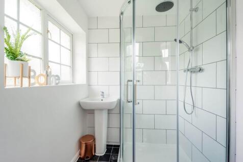 Bright, modern bathroom with a large glass show...