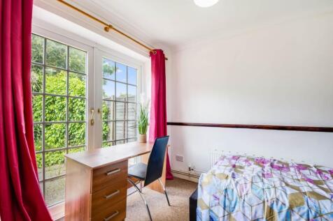 Bright, tidy bedroom with large patio-style win...