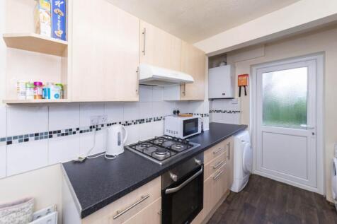 Bright, modern galley kitchen with light wood c...