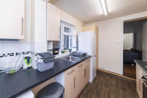 Modern galley-style kitchen with light wood cab...