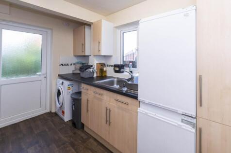 Bright, modern fitted kitchen with light wood c...