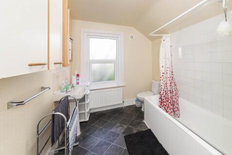 Bright, neatly presented bathroom with a white ...
