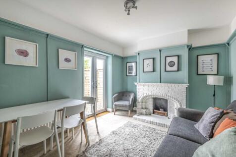 Bright, stylish living room with soft teal wall...