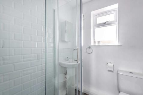 Bright, modern bathroom with a glass-enclosed s...