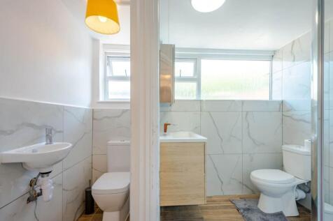 Bright, modern bathroom with clean marble-effec...