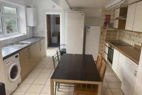 Bright galley-style kitchen with tiled floor, i...