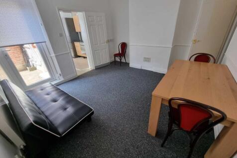 Bright, simply furnished living room with a lar...