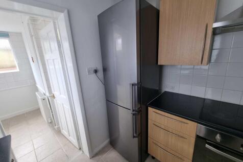 Compact modern kitchen with fitted cabinetry, a...