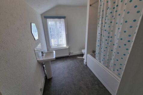 Bright bathroom with a bathtub and shower curta...