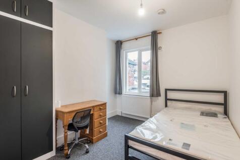 Bright, simply furnished bedroom with a double ...