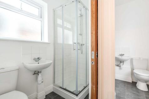 Bright, modern bathroom with a corner glass sho...
