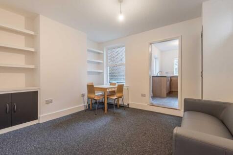 Bright, neutral communal lounge with built-in s...