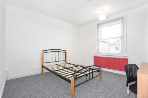 Bright, simply furnished bedroom with neutral w...