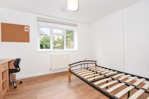 Bright, tidy bedroom with a large window, wood-...