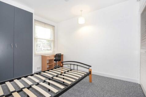 Bright, freshly painted bedroom with a large wi...