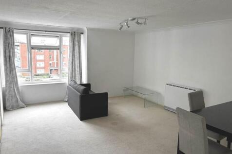 Bright, neutral living room with large bay wind...