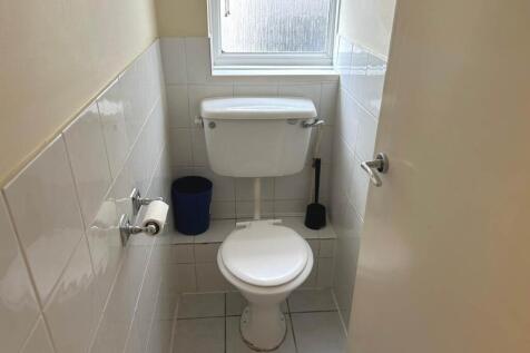 Neat and bright WC with white tiles, a standard...