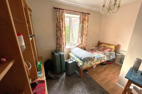 Cosy bedroom with a single bed by a window, fit...