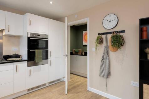 An adjoining utility area offers space to host laundry appliances