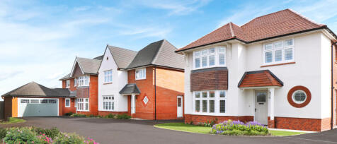 Modern detached houses with red brick and white exterior, bay windows, and landscaped front gardens