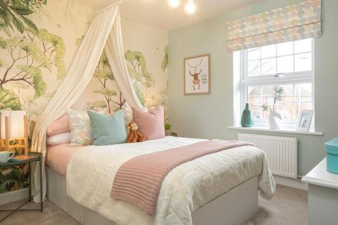 Children&#39;s bedroom with tree print wallpaper and white fabric canopy above the bed
