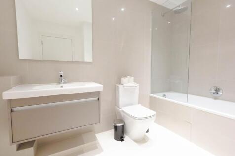 A modern and pristine bathroom featuring a slee...
