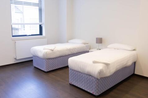 A spacious and well-lit double bedroom, perfect...