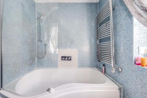Bright and clean bathroom suite featuring a mod...