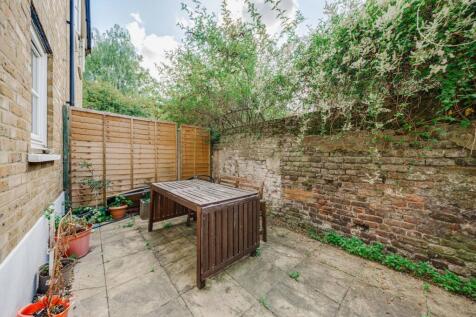 A cozy garden area featuring a wooden table and...