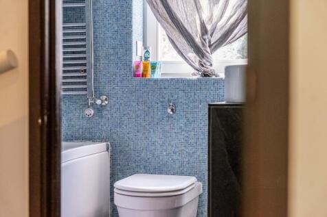 Bright bathroom featuring a white toilet and ba...