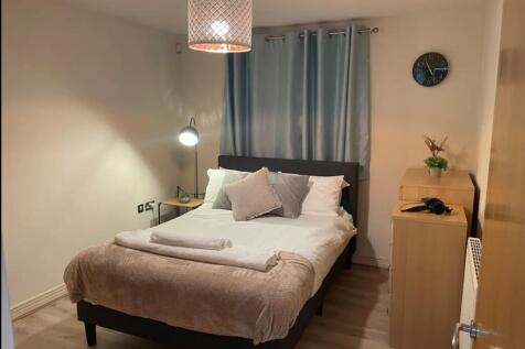 A cozy and well-lit double bedroom featuring mo...