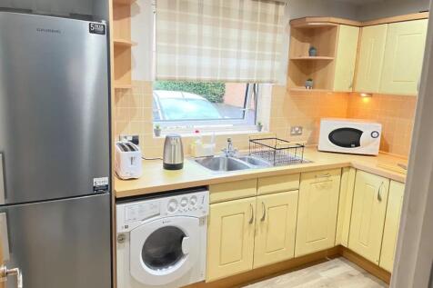 A bright and tidy kitchenette equipped with mod...