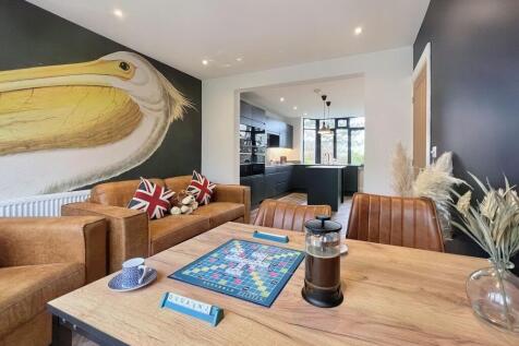 A stylish living room featuring warm brown leat...