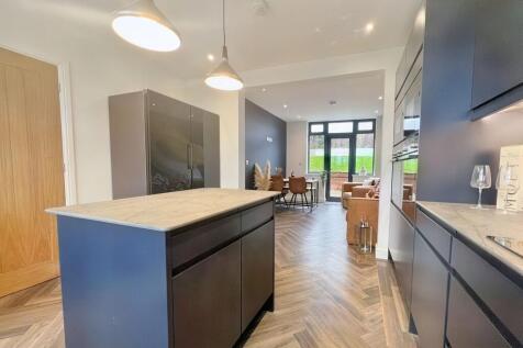 Modern kitchen featuring a large central island...