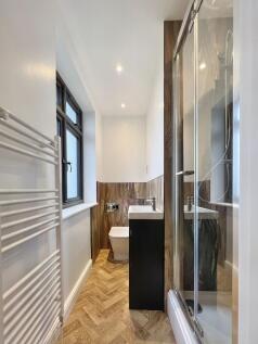 A modern bathroom featuring a sleek walk-in sho...