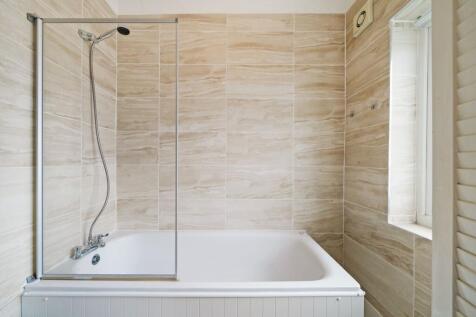 Bright and modern bathroom suite featuring a cl...