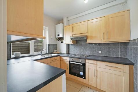 A neat and functional kitchen featuring light w...