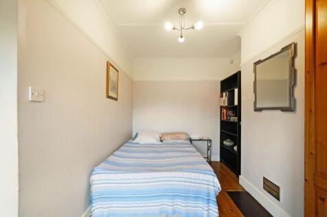 Cozy single bedroom featuring a neatly made bed...