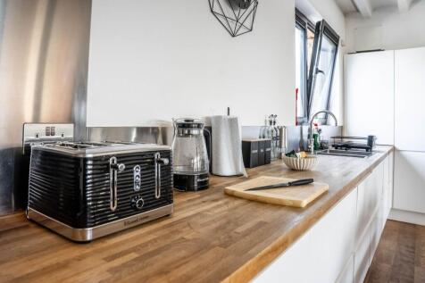 A modern kitchen featuring sleek countertops an...