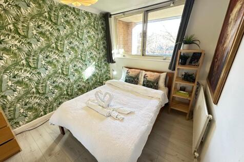 A cozy double bedroom featuring a stylish tropi...