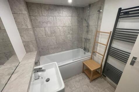 Bright and modern bathroom suite featuring a cl...