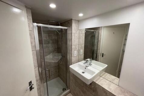 A modern bathroom featuring a clean glass showe...