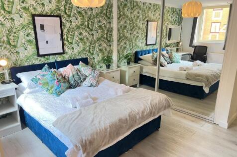 A stylish and bright master bedroom featuring a...